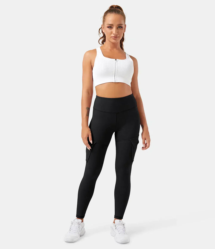 Frau in schwarzer Cargo-Leggings und weißem Sport-BH, Fitnessmode, bequeme Sportbekleidung.