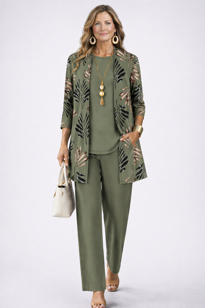 Modelka v olivově zelené soupravě s kardiganem s potiskem listů, kabelkou a dřevěnými náušnicemi 1