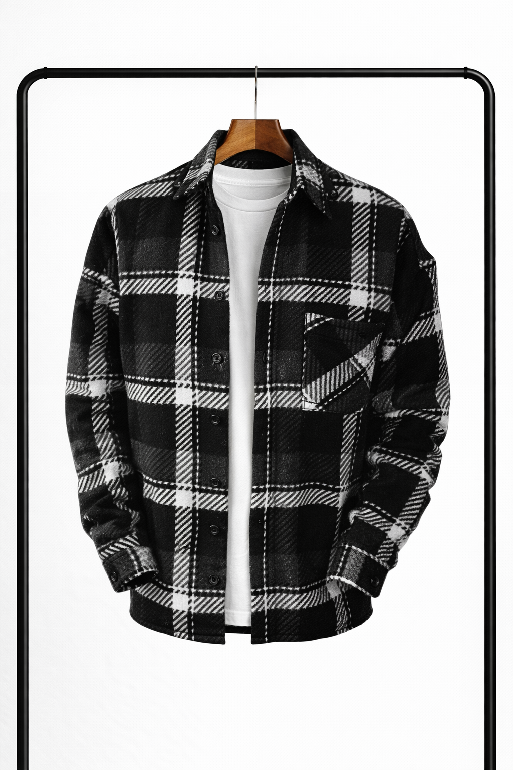 Černo-bílá kostkovaná overshirt rozepnutá přes bílé tričko, zavěšená na ramínku, s náprsní kapsou a černými knoflíky. 3
