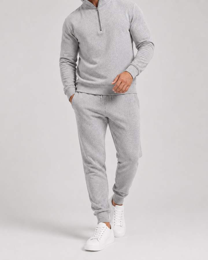 Detailnější záběr světle šedé melírované tepláčkové soupravy na modelovi od krku po tenisky, bez obličeje 2
