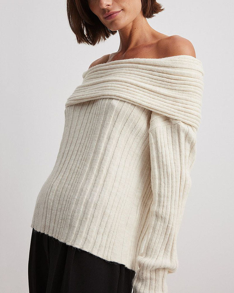 Frau trägt cremeweißen, schulterfreien Strickpullover, modisch, elegant, Herbstmode.