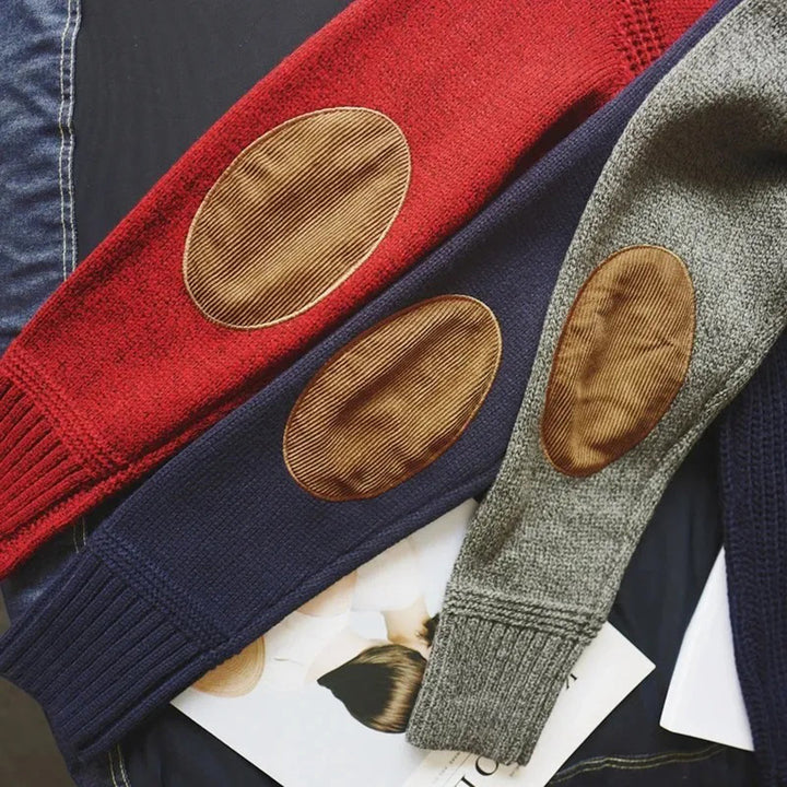 Rote, blaue und graue Strickpullover mit braunen Ellbogen-Patches auf dunklem Hintergrund.