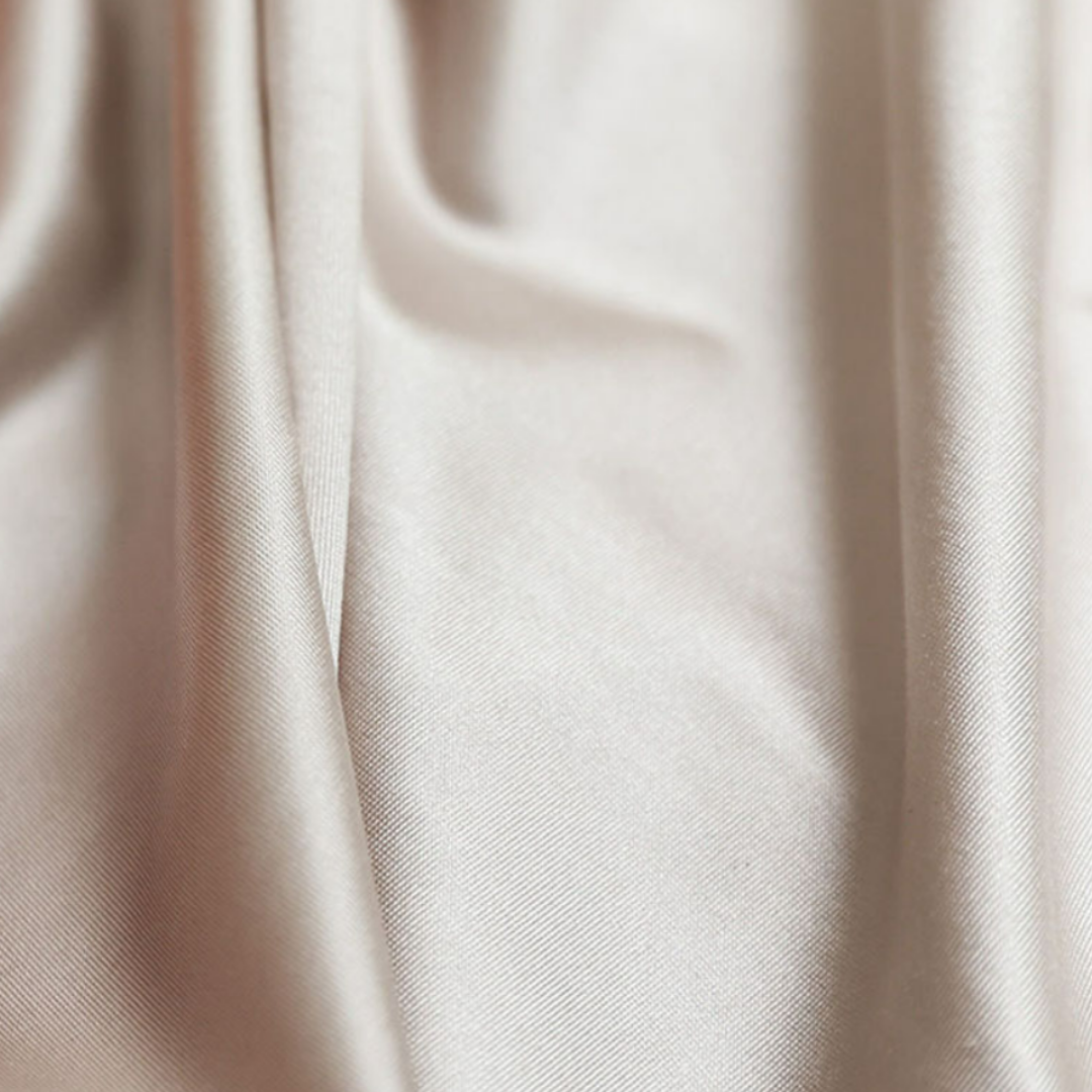 Beiger Satin-Stoff, luxuriös, glatt, ideal für elegante Mode und Heimtextilien.
