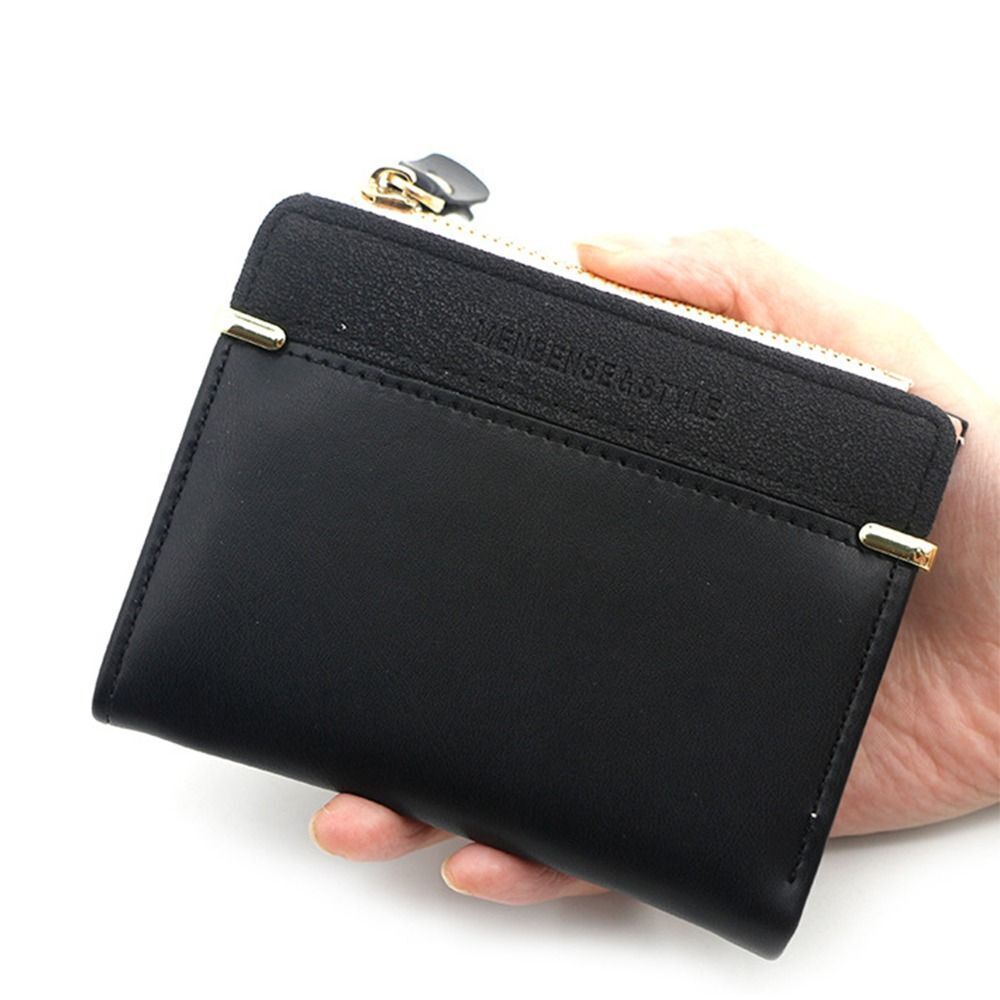 Schwarzes Mini-Kartenetui aus Leder mit Reißverschluss, handgehalten, stilvoll und kompakt.