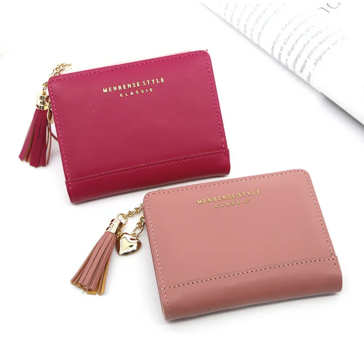 Zwei Mini-Kartenetuis aus Leder, rosa und rot, mit Quastenanhänger, stilvoll und kompakt.