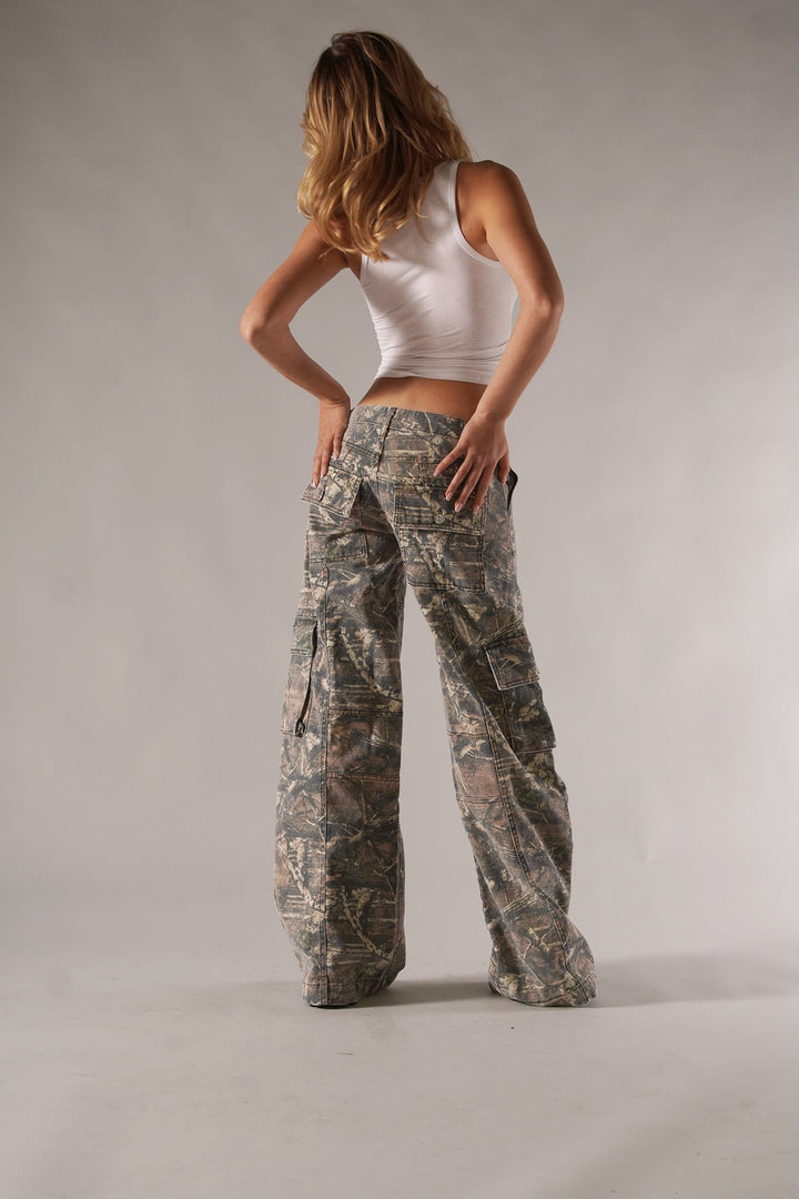 Frau in weißem Tanktop und Camouflage-Cargohose, Mode, Freizeitkleidung, Rückansicht.