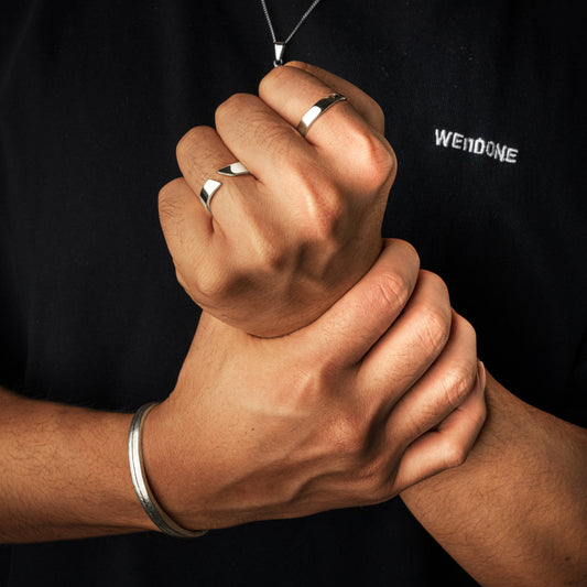 Mann mit silbernen Ringen und Armband, schwarzes T-Shirt, Schmuckmode Accessoires.