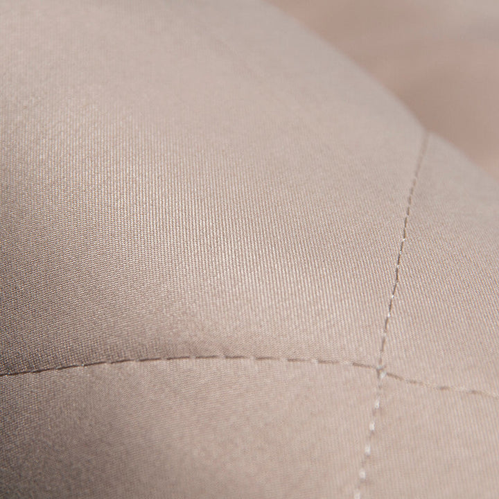 Beigefarbener, gesteppten Stoff, Nahaufnahme, Textur, Polstermaterial, hochwertig, Detailansicht.