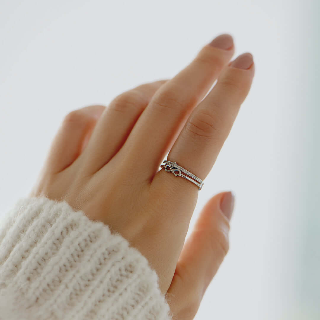 Hand mit silbernem Verlobungsring, Zirkonia, Damenmode, Nahaufnahme, elegantes Schmuckdesign.