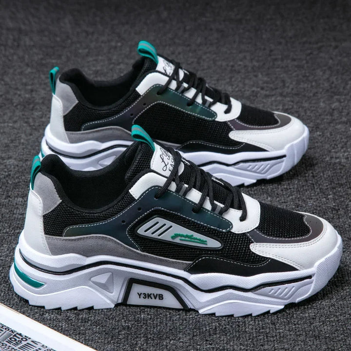 Schwarze und weiße Sneaker, atmungsaktiv, modisch, mit grünen Akzenten, auf grauem Hintergrund.