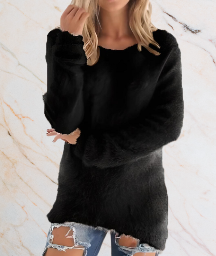 Frau in schwarzem Pullover aus Kunstfell, zerrissene Jeans, Marmorhintergrund.