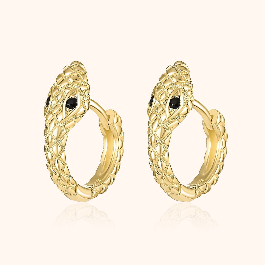 Goldene Schlangen-Ohrringe mit schwarzen Steinen, elegantes Schmuckdesign, luxuriöses Accessoire.