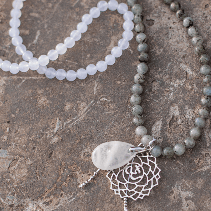 Halskette mit weißen und grauen Perlen, silberner Anhänger, handgefertigter Schmuck.