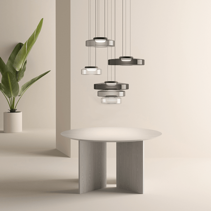 Moderne Hängelampen über rundem Holztisch, minimalistisches Design, neutrale Farben.
