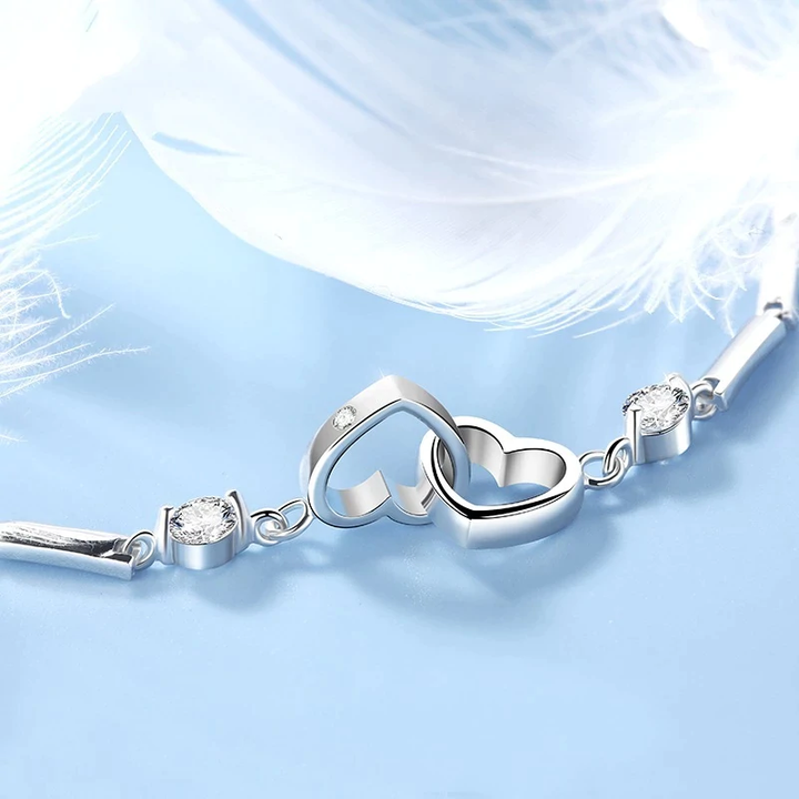 Silberarmband mit Herzanhänger und Kristallen, eleganter Schmuck für Damen, romantisches Design.