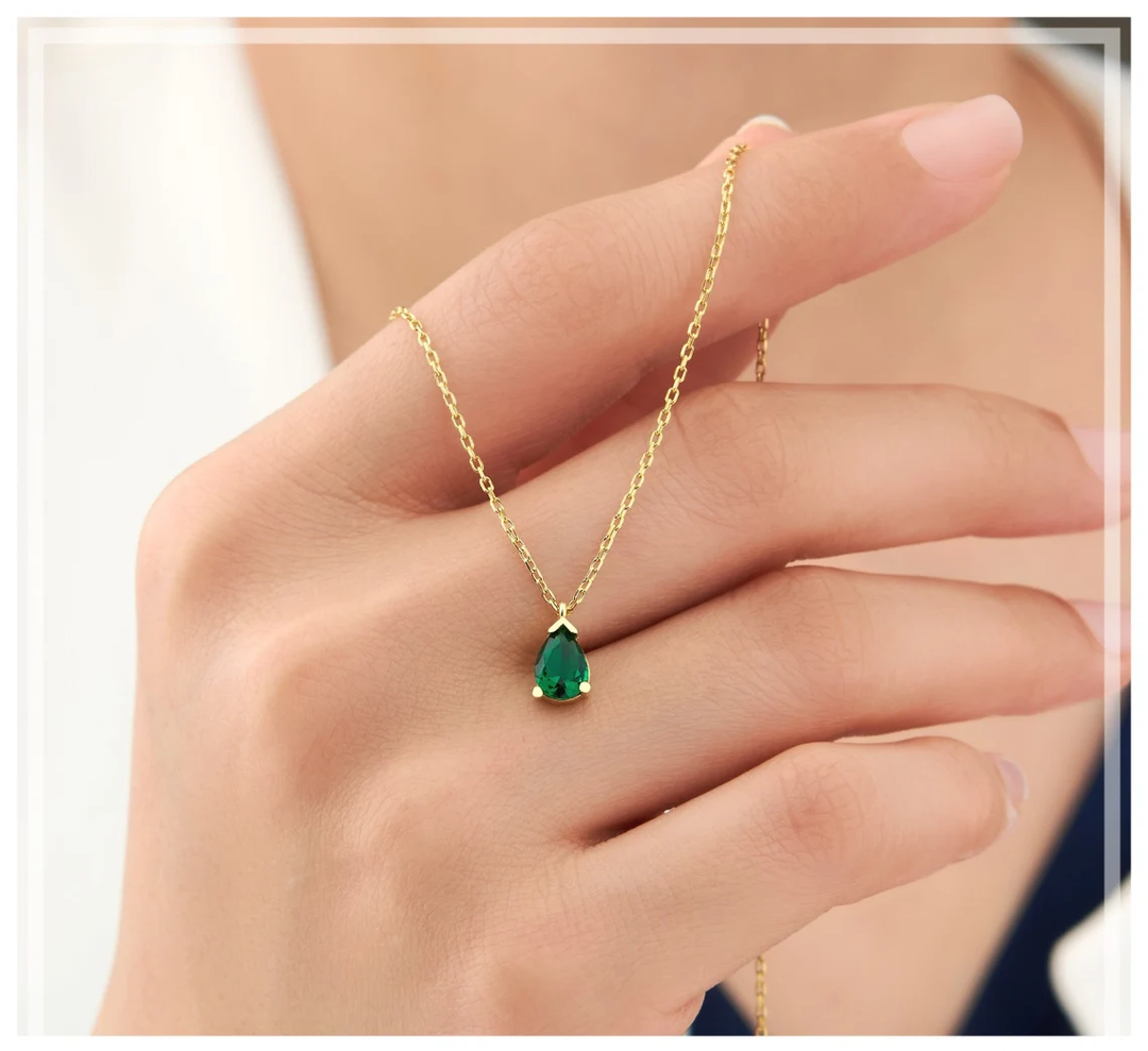 Goldene Halskette mit tropfenförmigem Smaragd-Anhänger, eleganter Schmuck für Damen.