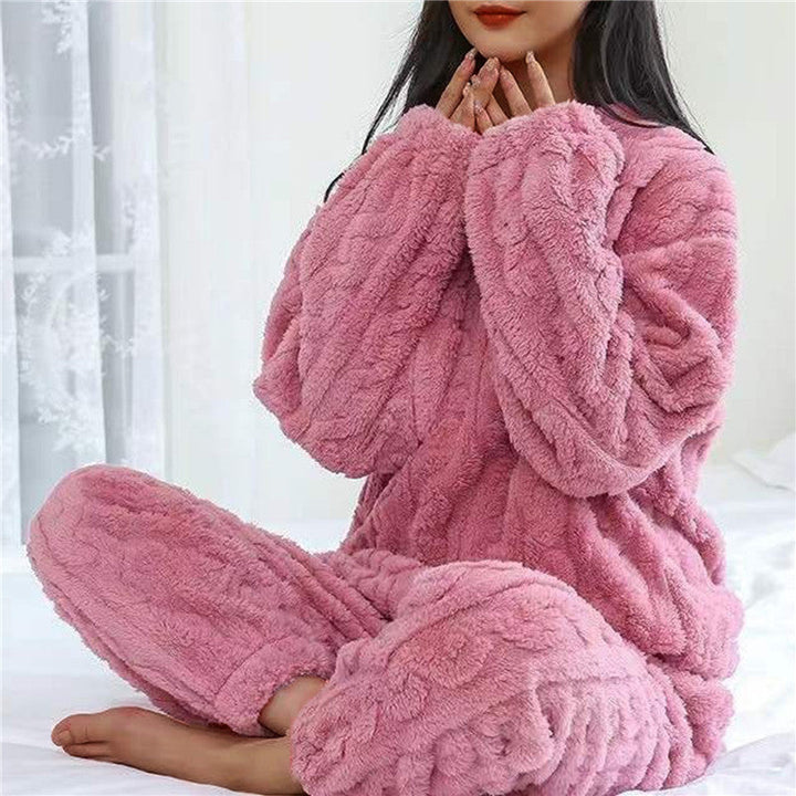 Růžová plyšová souprava na modelce sedící po turecku s rukama u brady před bílou záclonou 6