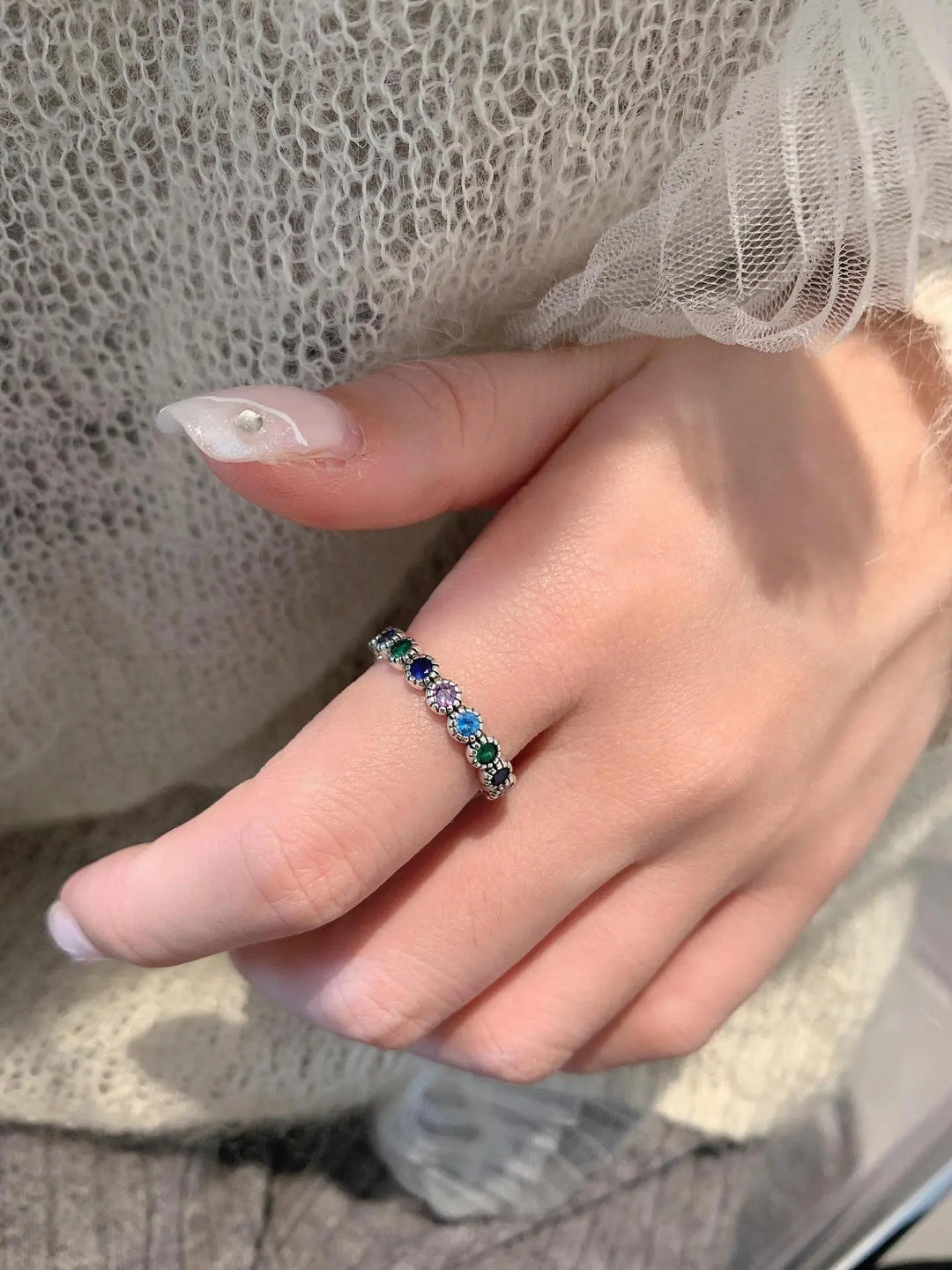 Damenring mit blauen und grünen Edelsteinen, Silber, elegantes Schmuckdesign, Nahaufnahme.