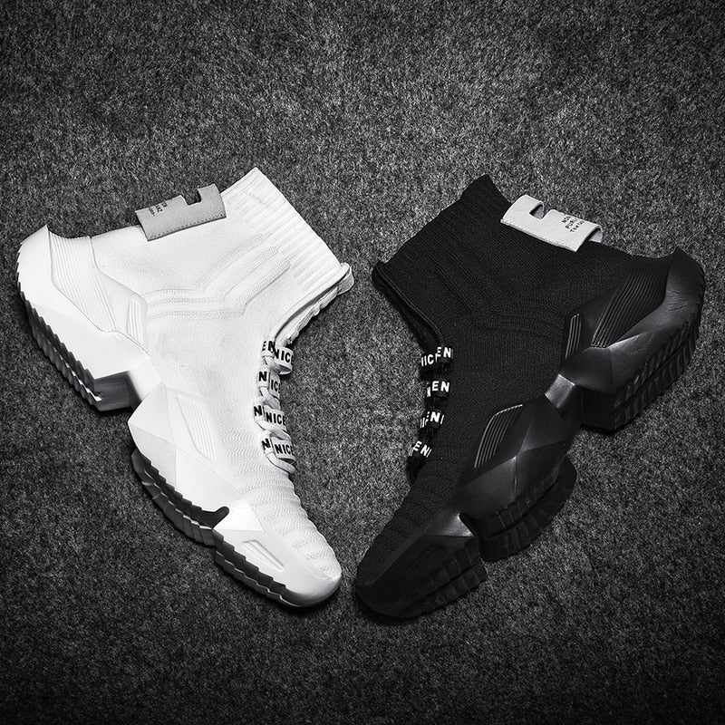 Weiße und schwarze Sneaker, gestricktes Obermaterial, rutschfeste Sohle, modisches Design.