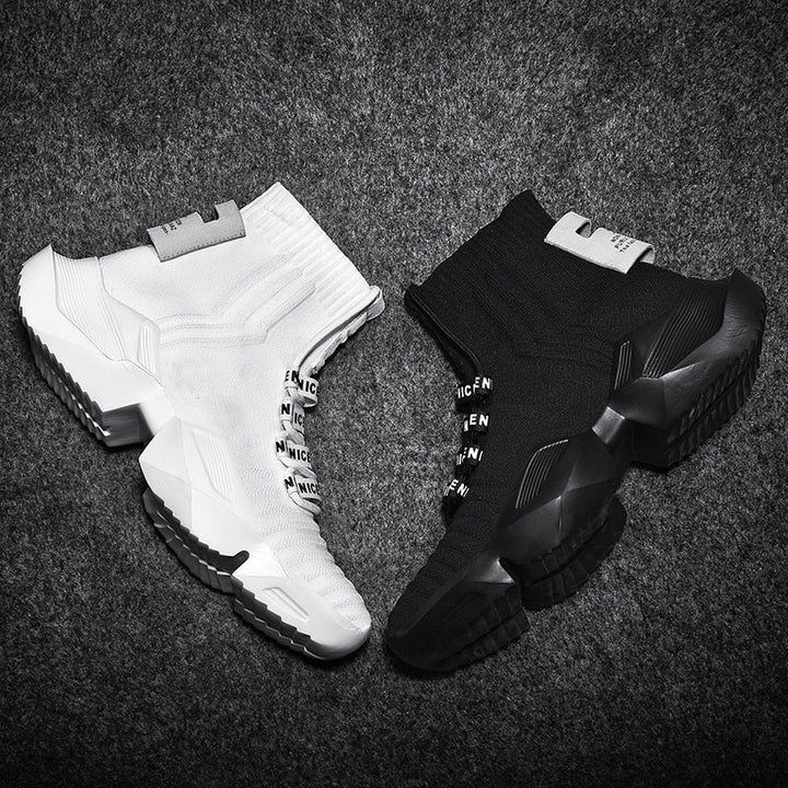 Weiße und schwarze Sneaker, gestricktes Obermaterial, rutschfeste Sohle, modisches Design.
