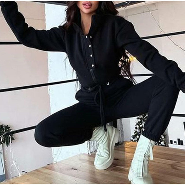 Frau in schwarzem Jumpsuit und weißen Stiefeln, modische Freizeitkleidung, Indoor-Aufnahme.