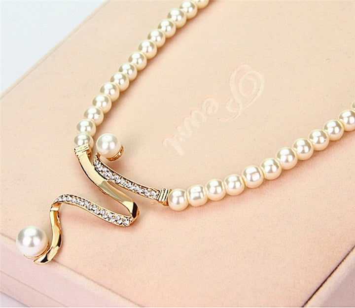 Perlenkette mit goldenen Details und Strasssteinen auf beigem Hintergrund, eleganter Schmuck.