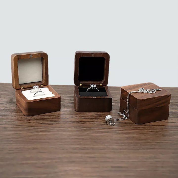 Drei Holz-Ringboxen mit Verlobungsringen auf Holztisch, Schmuckaufbewahrung, Geschenkboxen.
