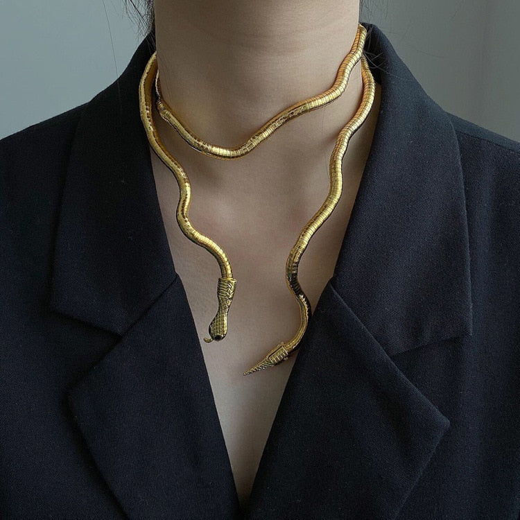 Goldene Schlangen-Halskette, Damenmode, elegantes Schmuckdesign, schwarzer Blazer-Hintergrund.