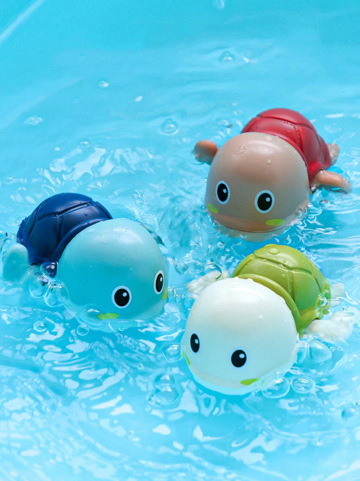 Bunte schwimmende Schildkröten-Badespielzeuge im Wasser, Kunststoff, Kinder, blau, rot, grün.