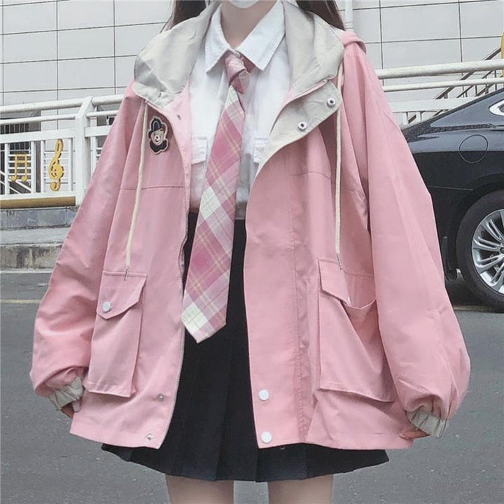 Damenmode rosa Jacke mit Kapuze, weißes Hemd, karierte Krawatte, schwarzer Rock, lässiger Stil.
