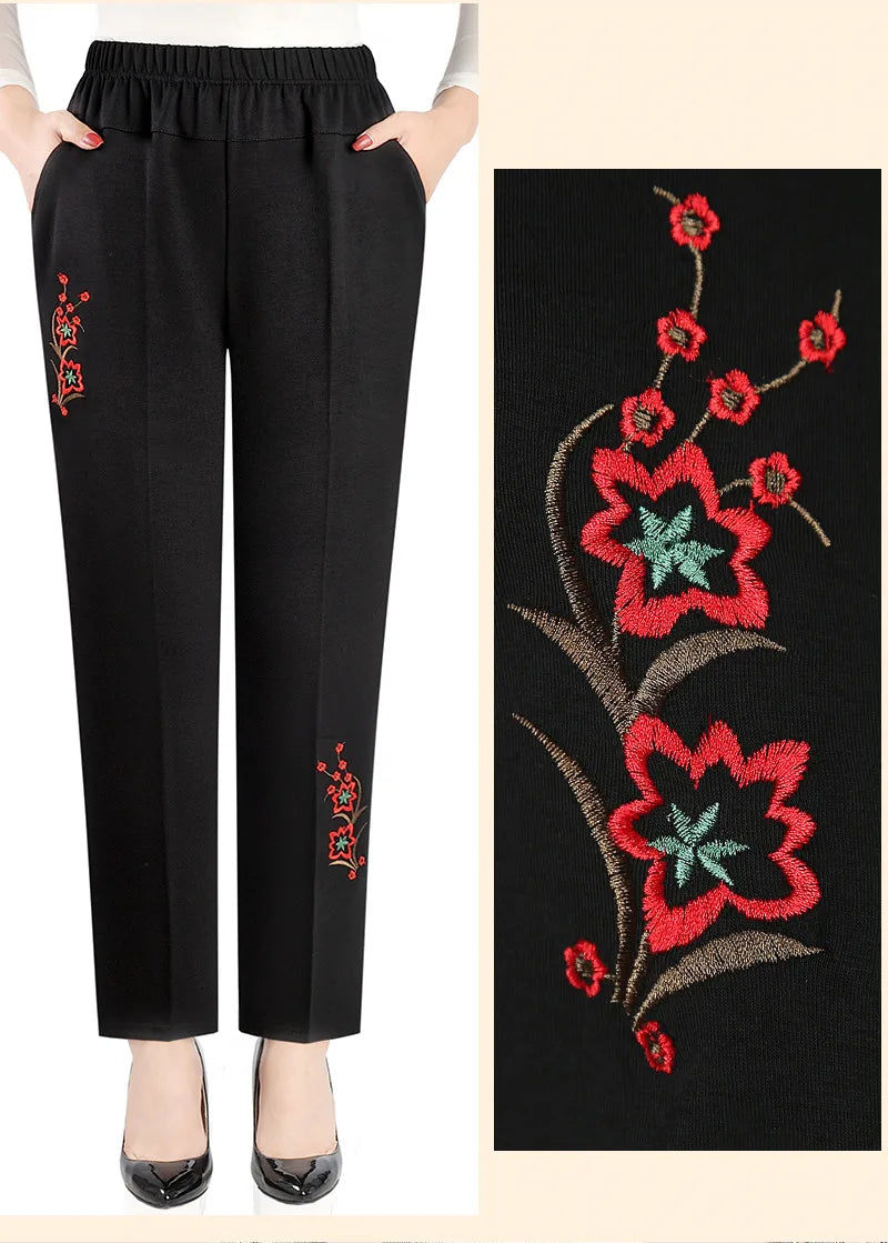 Schwarze Damenhose mit roter Blumenstickerei, elastischer Bund, elegant, modisch.