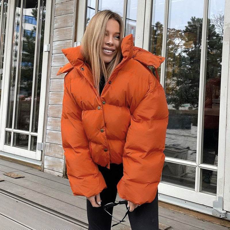 Frau in orangefarbener Daunenjacke, Wintermode, Outdoor, warm, stilvoll, modisch, Herbst.