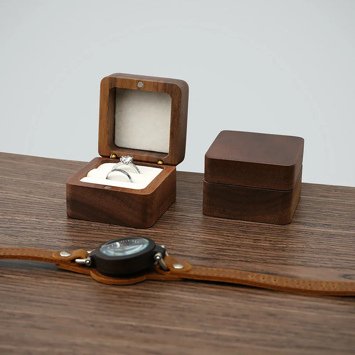 Holzringbox mit Diamantring, quadratisch, auf Holztisch, luxuriöses Schmuckdisplay.
