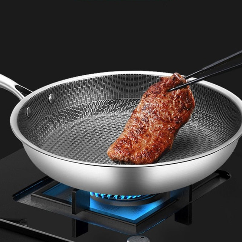 Edelstahlpfanne mit Steak auf Gasherd, Antihaftbeschichtung, Kochen, Küche, Bratpfanne.