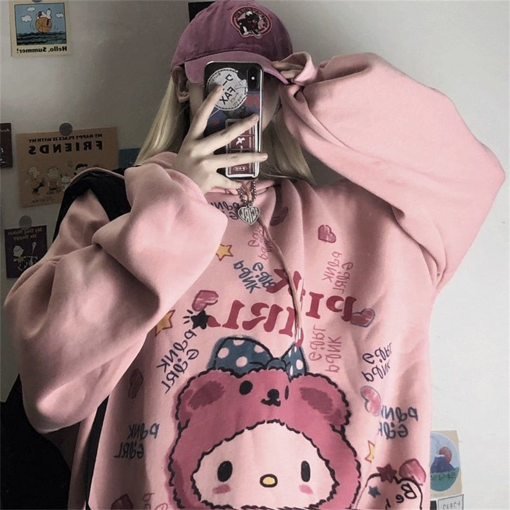 Frau in rosa Hello Kitty Pullover und Mütze, Selfie im Spiegel, modisches Streetwear-Outfit.