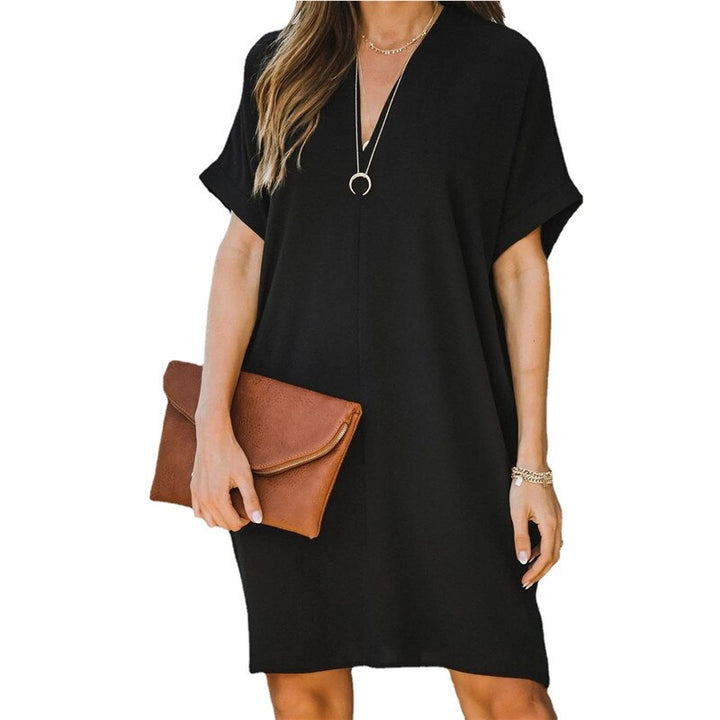 Frau in schwarzem Kleid mit brauner Clutch, lässiger Sommerlook, Modeaccessoires.