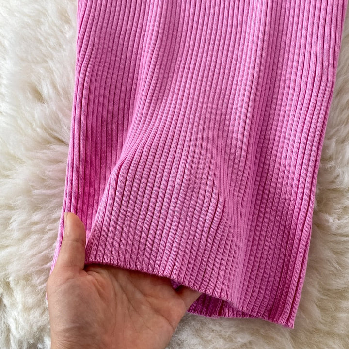 Rosa gerippter Strickstoff, weich, ideal für Pullover oder Strickwaren, auf weißem Hintergrund.