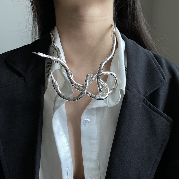 Silberne Schlangen-Halskette, modisch, Damen, elegantes Design, auf weißer Bluse und schwarzem Blazer.