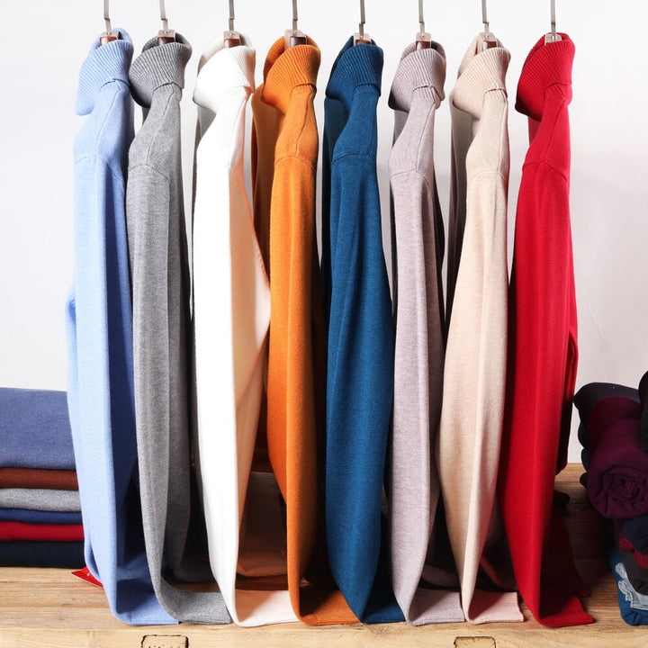 Bunte Pullover aus Baumwolle auf Kleiderbügeln, verschiedene Farben, modische Herrenbekleidung.