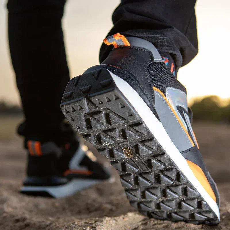 Schwarze Laufschuhe mit orangefarbenen Akzenten, Profilsohle, Outdoor, Sportbekleidung.