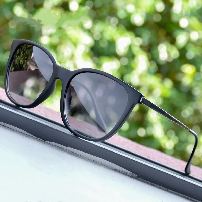 Schwarze Sonnenbrille mit runden Gläsern auf Fensterbank, modisches Accessoire, UV-Schutz.