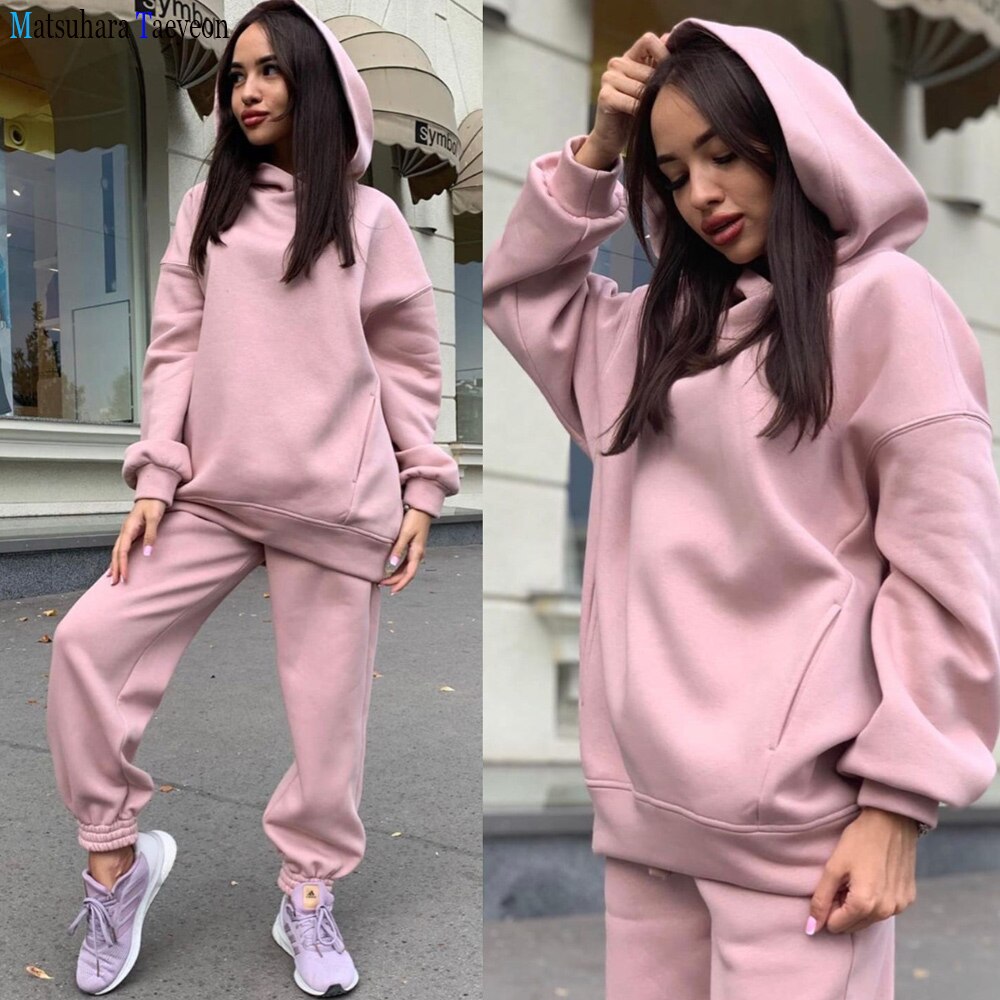 Frau in rosa Kapuzenpullover und Jogginghose, lässige Mode, bequeme Freizeitkleidung.