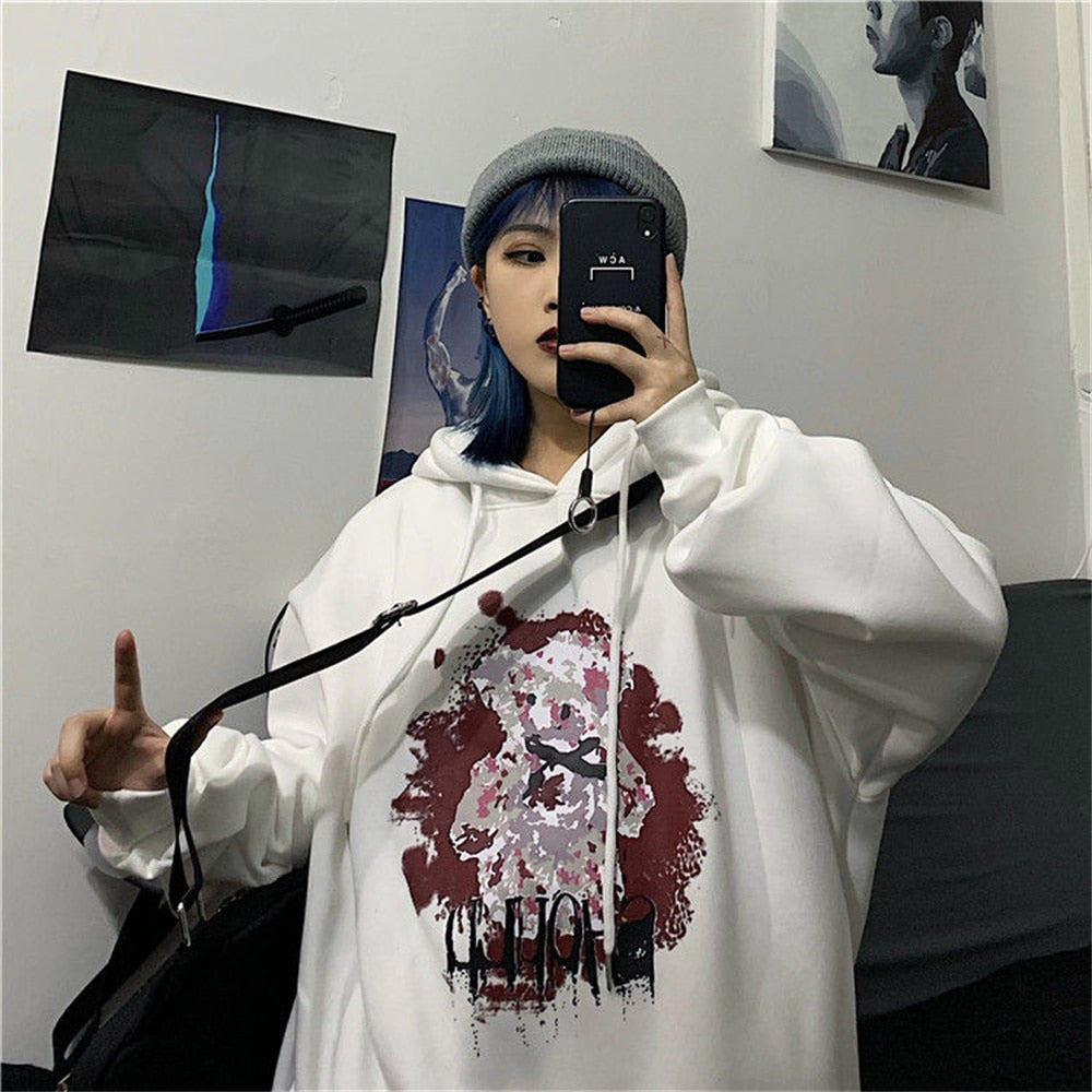 Frau in weißem Hoodie mit Kunstmotiv, graue Mütze, Selfie im Spiegel, urbaner Stil.