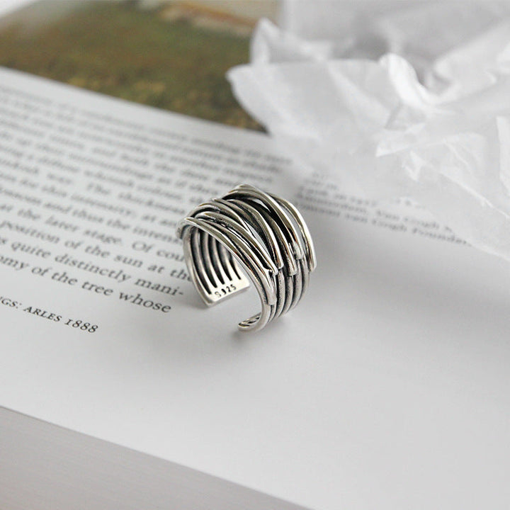 Silberner, verstellbarer Ring auf Buchseite, modernes Design, Schmuck für Damen und Herren.