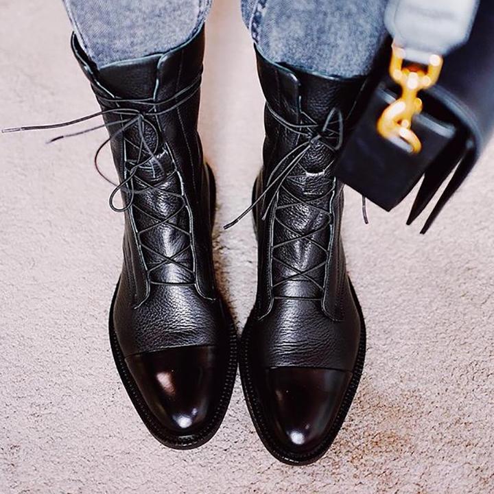 Schwarze Lederstiefel mit Schnürung, Damenmode, elegante Herbst-Winter-Schuhe, Nahaufnahme.
