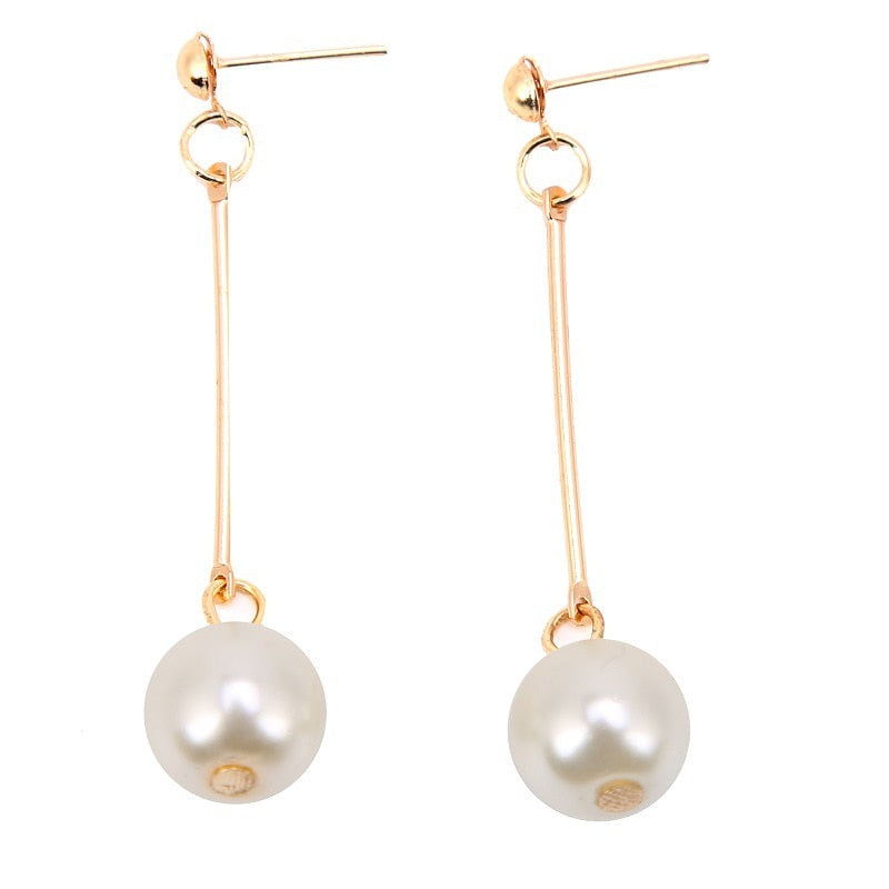Goldene Ohrringe mit langen Stäben und weißen Perlen, eleganter Schmuck für Damen.