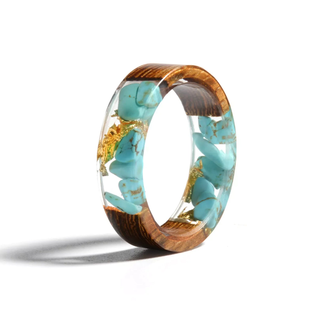 Handgefertigter Ring aus Holz und Harz mit türkisfarbenen Steinen, einzigartiges Schmuckdesign.