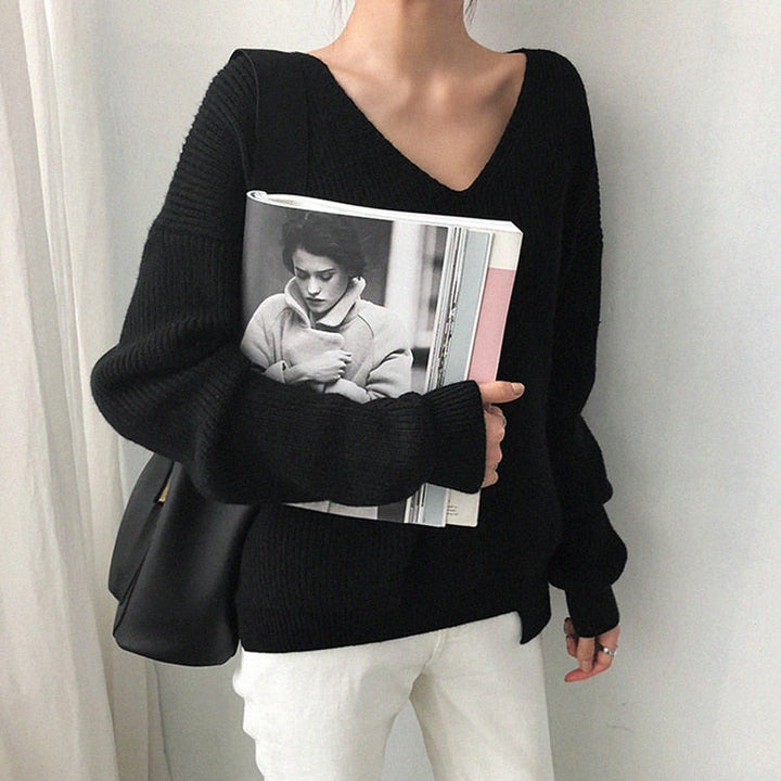 Frau in schwarzem V-Ausschnitt-Pullover, hält Magazin, modisch, lässig, Herbstmode.