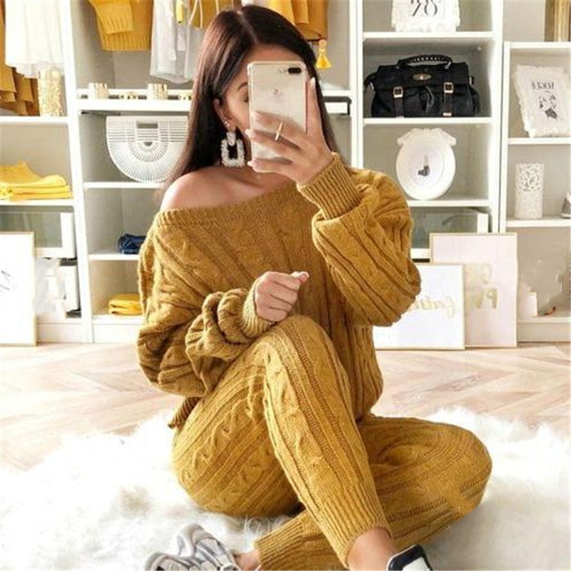 Frau in senfgelbem Strickpullover und Hose, gemütliches Herbstoutfit, Wohnzimmer-Hintergrund.
