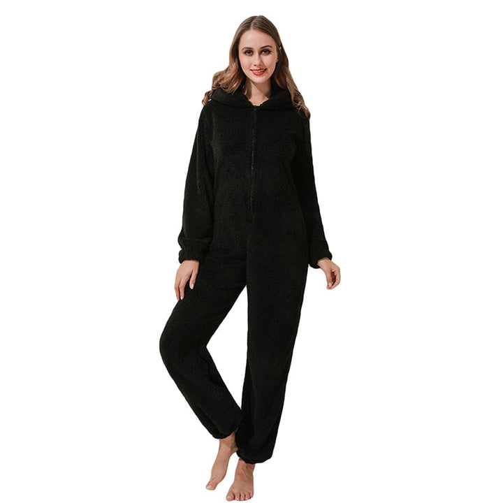 Frau in schwarzem Fleece-Overall mit Kapuze, gemütliche Damenbekleidung, Ganzkörperanzug.